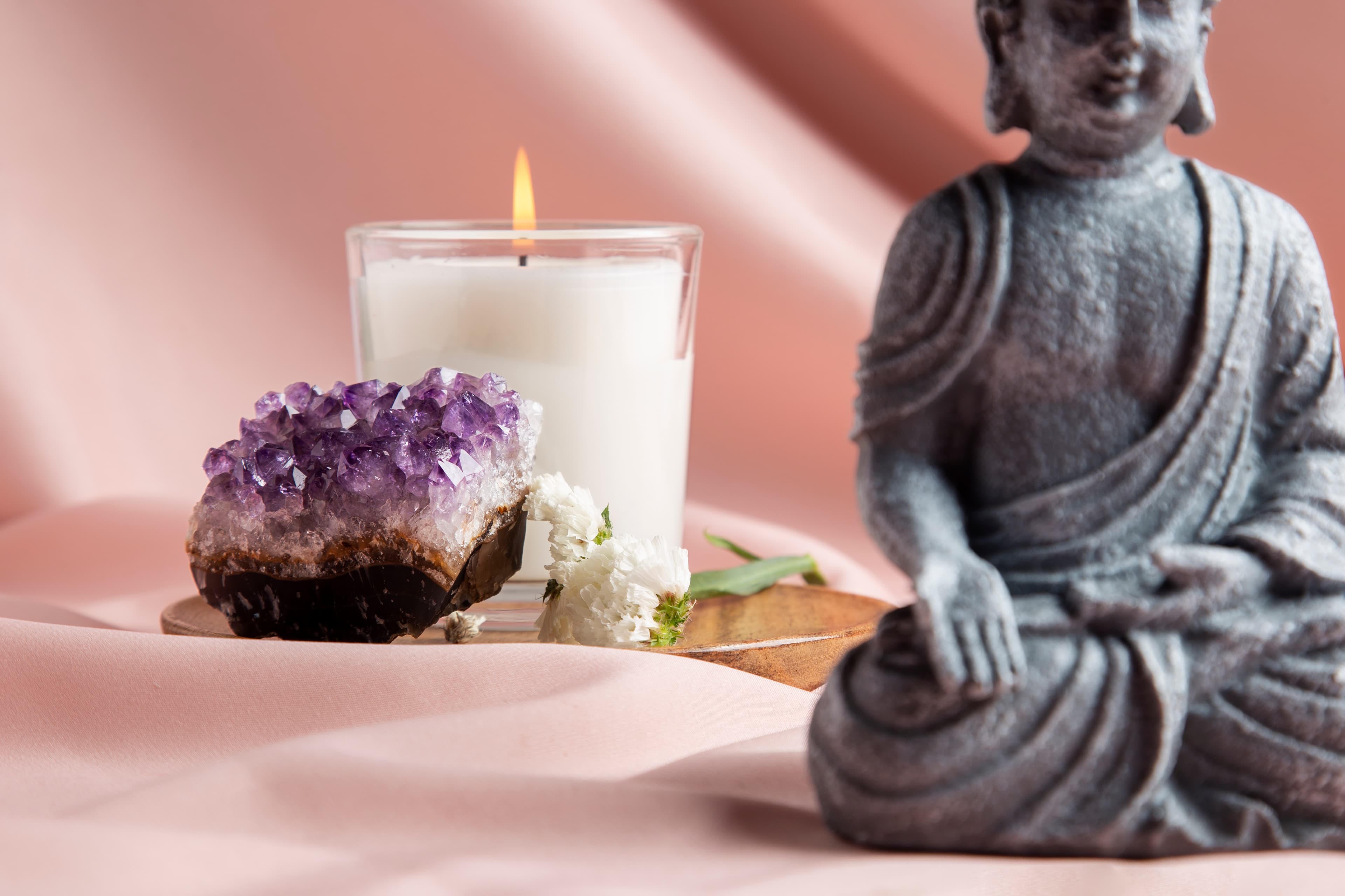 Meditation space with amethyst, candle and Buddha statue